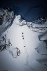 Quatro esquiadores caminhando por uma encosta íngreme no sertão da área de esqui Gastein, Salzburgo, Áustria — Fotografia de Stock
