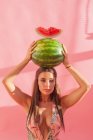 Frau hält Wassermelone über Kopf — Stockfoto