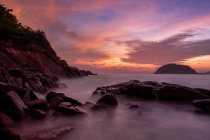 Olas que se estrellan sobre rocas costeras al amanecer, Isla Redang, Terengganu, Malasia - foto de stock