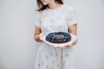 Woman holding a Blueberry chocolate brownie cake — Stock Photo