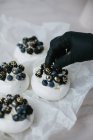 Femme décoration Pavlova desserts aux myrtilles et mûres — Photo de stock
