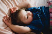 Close-up de uma menina dormindo com os braços acima da cabeça — Fotografia de Stock