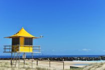 Torre de salvavidas y horizonte de Gold Coast en la distancia, Queensland, Australia - foto de stock