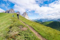 Dos personas en bicicleta de montaña por encima de Passo Sella, Val Gardena, Tirol del Sur, Italia - foto de stock