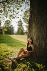 Жінка сидить під деревом у парку (Сербія). — стокове фото