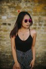 Stylische asiatische junge Frau steht vor alter Backsteinmauer — Stockfoto