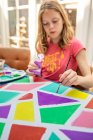 Girl sitting at a table painting — Stock Photo
