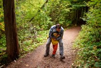 Vater und Sohn tummeln sich im Wald, USA — Stockfoto
