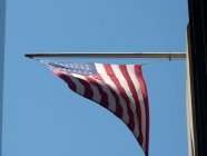 Bandera estadounidense contra el cielo azul, Manhattan, Nueva York, Estados Unidos - foto de stock