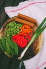 Elevated view of lima beans, spring onion, tofu, mangetout and peppers on a chopping board — Stock Photo