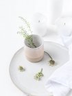 Piatto e tazza in ceramica con fiori di campo e candele — Foto stock