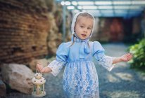 Retrato de una niña con un vestido vintage que lleva una linterna, Bulgaria - foto de stock