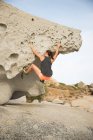Жінка піднімається на скелі на березі моря (Корсика, Франція). — стокове фото