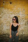 Élégant asiatique jeune femme debout en face de vieux mur de briques — Photo de stock