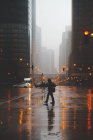 Silhueta de um homem atravessando a rua em uma noite nebulosa, Chicago, Illinois, Estados Unidos — Fotografia de Stock