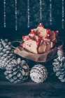 Bucket of Santa cookies surrounded by Christmas pine cones — Stock Photo