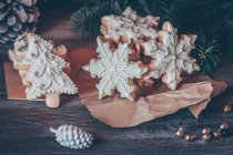 Copo de nieve y galletas de árbol de Navidad rodeados de decoraciones navideñas - foto de stock