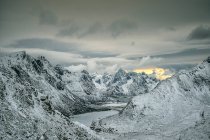 Montañas cubiertas de nieve, Flakstad, Lofoten, Nordland, Noruega - foto de stock