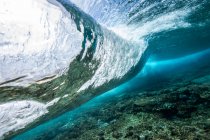 Vista submarina de una ola rompiendo un arrecife de coral, Maldivas - foto de stock