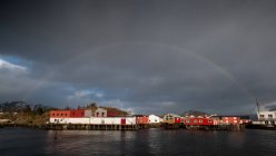 Рейнбоу над прибрежной деревней, Лоффелланд, Норвегия — стоковое фото