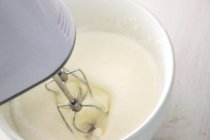 Close-up of an electric whisk whisking double cream — Stock Photo