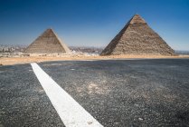 Camino más allá del complejo piramidal de Giza cerca de El Cairo, Egipto - foto de stock