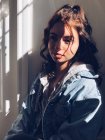 Retrato de adolescente con luz solar y sombras en la cara - foto de stock