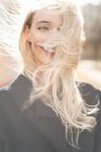 Porträt einer lächelnden Frau mit windgepeitschten Haaren — Stockfoto