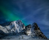 Luces boreales que se preparan sobre Mt Nappstinden, Lofoten, Nordland, Noruega - foto de stock