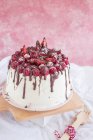 Raspberry and strawberry cream cake with chocolate on wooden board, close view — Stock Photo