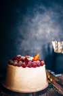 Raspberry and strawberry cream cake on wooden board, close view — Stock Photo