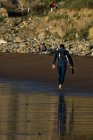 Surfer несе дошку на пляжі Сопелана, Біскай, Країна Басків, Іспанія — стокове фото