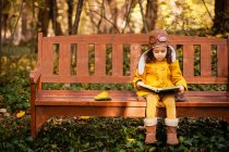Дівчинка сидить на лавці парку і читає книжку (Болгарія). — стокове фото