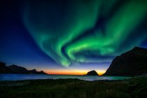 Verde aurora boreal luz sobre el paisaje montañoso con lago - foto de stock