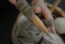 Mulher segurando uma bola de lã e agulhas de tricô — Fotografia de Stock