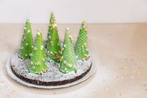 Árbol de Navidad con decoraciones y pan de jengibre en la mesa - foto de stock