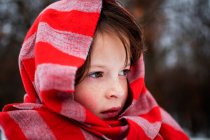 Retrato de una niña de pie en la nieve con una bufanda alrededor de la cabeza, Estados Unidos - foto de stock