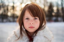 Retrato de una niña de pie en la nieve, Estados Unidos - foto de stock