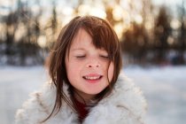 Retrato de una niña sonriente parada en la nieve, Wisconsin, Estados Unidos - foto de stock