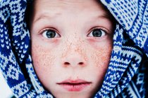 Close-up portrait of a boy with freckles wrapped in a scarf, United States — Stock Photo
