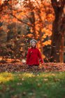 Ragazza che lancia foglie autunnali in aria, Stati Uniti — Foto stock
