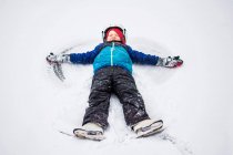 Boy lying in snow making a snow angel, Wisconsin, United States — Stock Photo