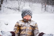 Хлопчик кидає сніг в зимовий парк сцена — стокове фото