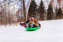 Two boys on a sledge laughing, Wisconsin, United States — Stock Photo