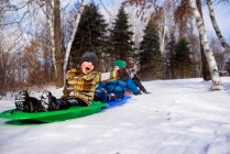 Three boys on a sledge laughing, Wisconsin, United States — Stock Photo