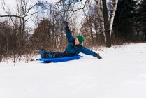 Boy on a sledge laughing, Wisconsin, États-Unis — Photo de stock