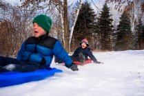 Due ragazzi su una slitta ridendo, Wisconsin, Stati Uniti — Foto stock