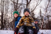 Portrait of three children sitting on a sledge, Wisconsin, United States — Stock Photo