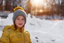 Porträt eines lächelnden Mädchens, das neben einer Schneefestung steht, USA — Stockfoto