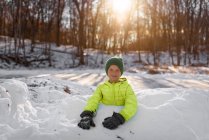 Sonriente niño de pie en un fuerte de nieve, Estados Unidos - foto de stock